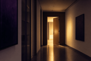 File: boutique-firms-put-you-first-featured.png Alt text: Open door at the end of a quiet corridor with warm light beyond — featured image for Teachers' Path post on advisor independence